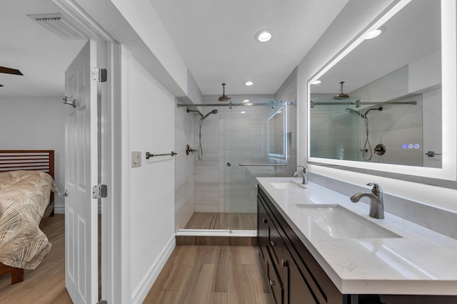 bathroom with wood-type flooring, an enclosed shower, and vanity