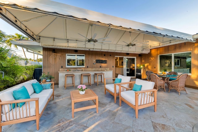 view of patio with an outdoor living space, an outdoor bar, and ceiling fan