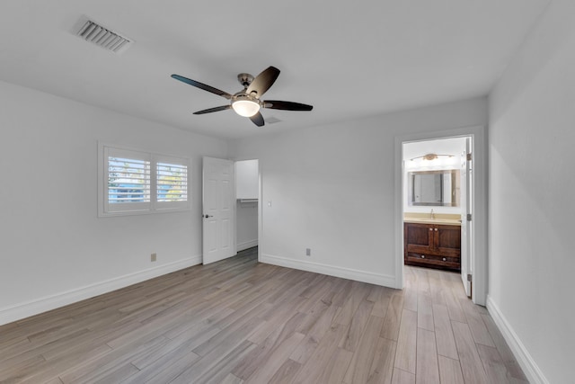 unfurnished bedroom with ceiling fan, sink, light hardwood / wood-style floors, and ensuite bath