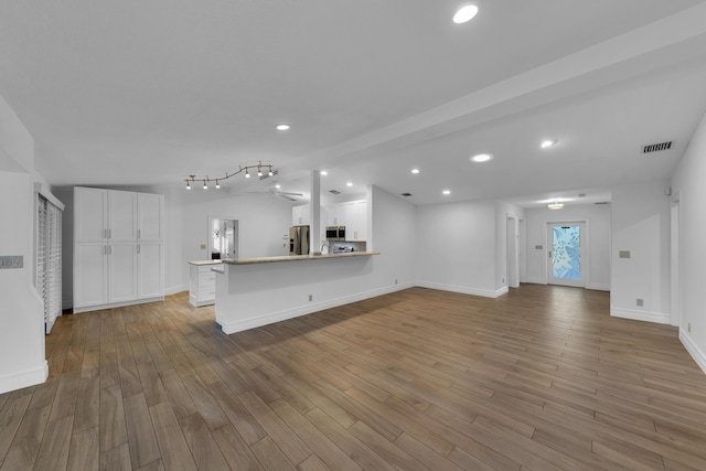 unfurnished living room with lofted ceiling and light hardwood / wood-style flooring