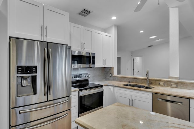 kitchen with sink, white cabinetry, light stone counters, tasteful backsplash, and stainless steel appliances