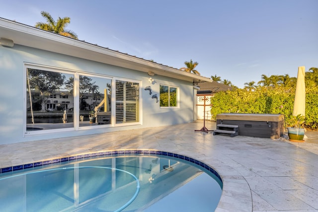 view of swimming pool featuring a hot tub and a patio area