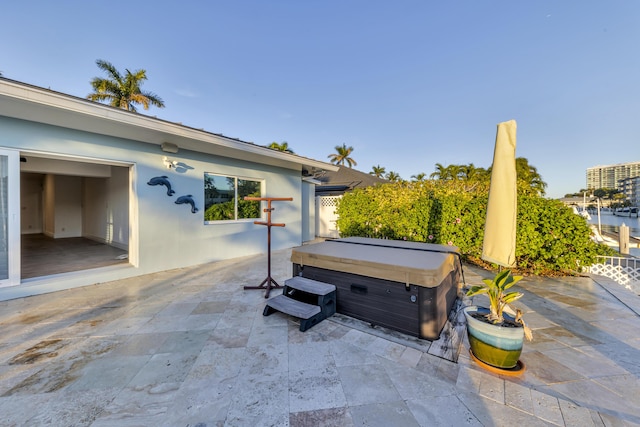 view of patio featuring a hot tub and a water view