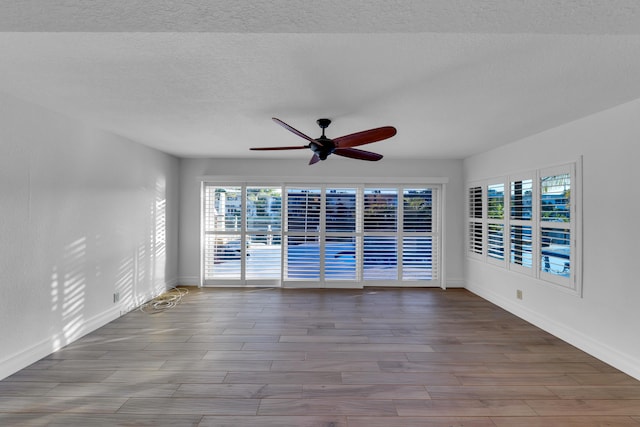 unfurnished room featuring a textured ceiling, ceiling fan, and light hardwood / wood-style flooring