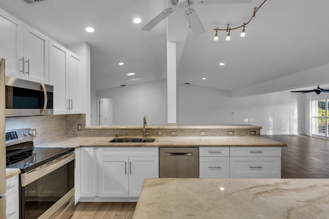 kitchen with white cabinetry, appliances with stainless steel finishes, sink, and light stone counters