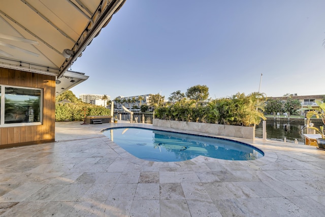 view of pool with a water view and a patio