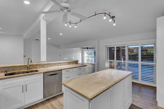 kitchen featuring sink, dishwasher, light stone countertops, white cabinets, and light wood-type flooring