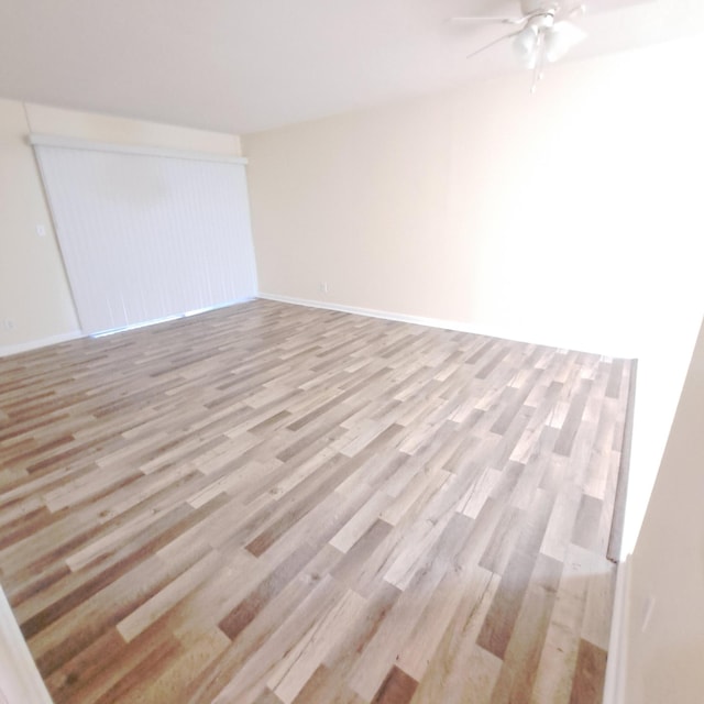 spare room with ceiling fan and light wood-type flooring