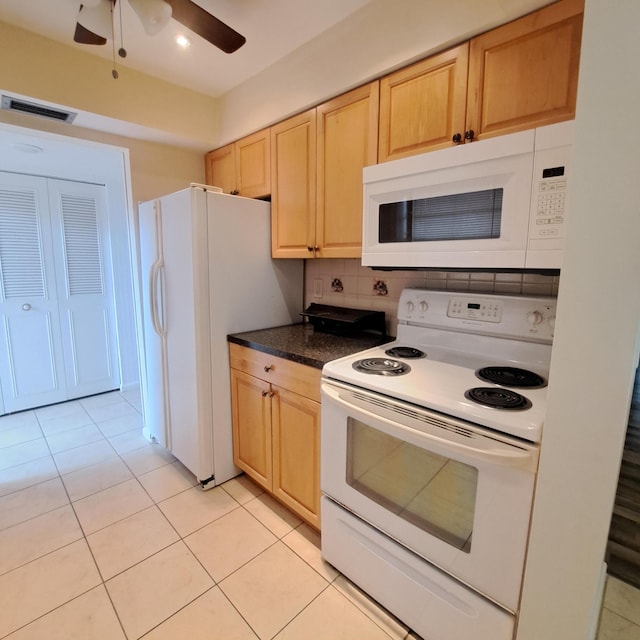 kitchen with light tile patterned flooring, white appliances, and light brown cabinetry