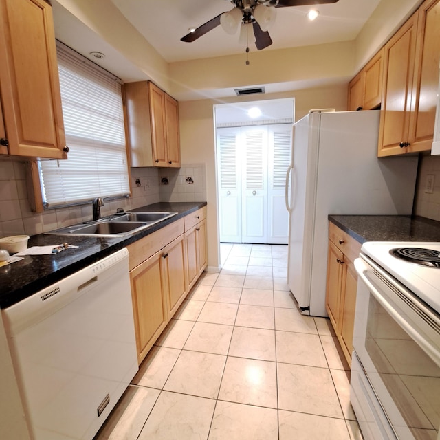 kitchen featuring light brown cabinetry, sink, white appliances, and tasteful backsplash