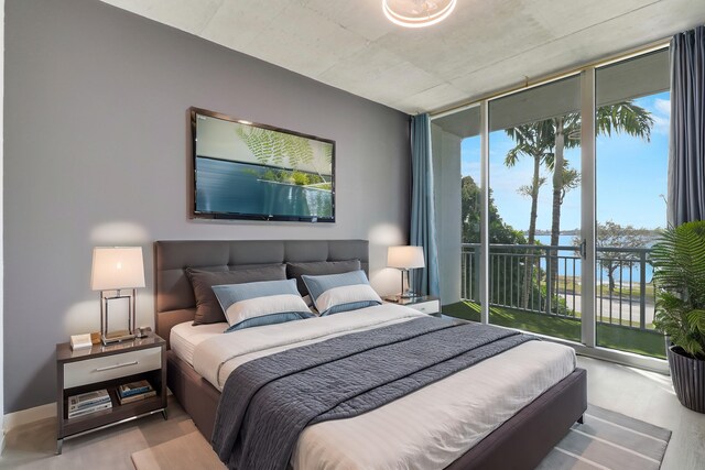 empty room featuring light hardwood / wood-style floors, expansive windows, and a water view