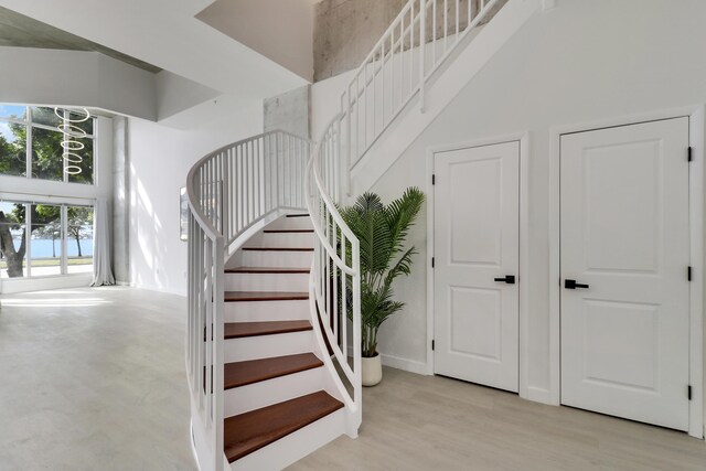 stairs featuring a high ceiling and wood-type flooring