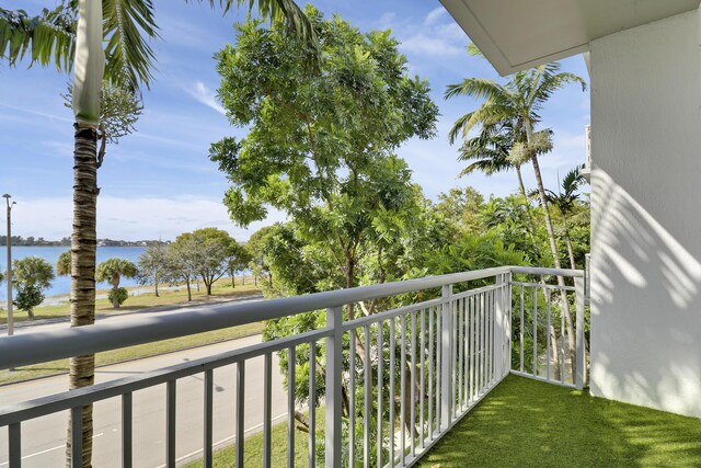 bedroom featuring a water view, floor to ceiling windows, and access to exterior