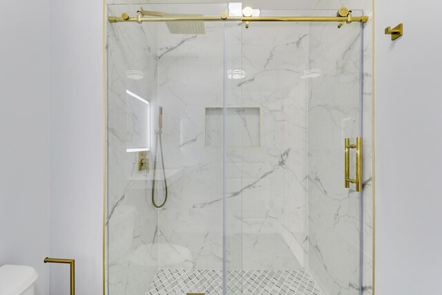 bathroom featuring a shower with door, vanity, and toilet