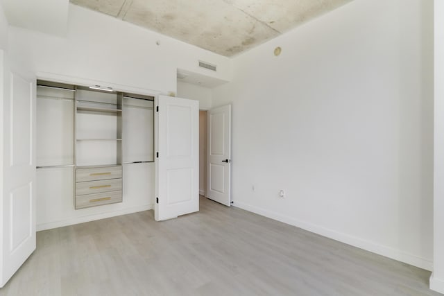 unfurnished bedroom with light hardwood / wood-style floors and a closet