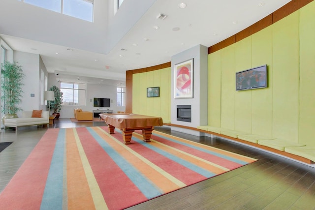 game room featuring a high ceiling, dark hardwood / wood-style floors, and billiards