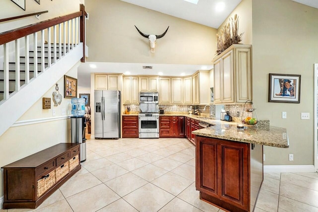 kitchen with high vaulted ceiling, a breakfast bar area, stainless steel appliances, a peninsula, and decorative backsplash