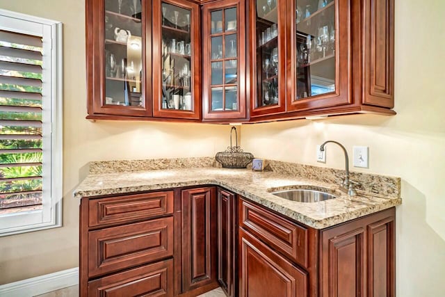 bar featuring indoor wet bar, a sink, and baseboards