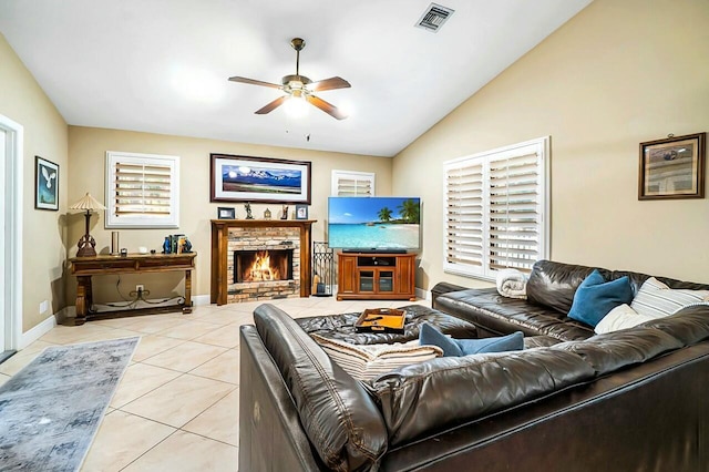 living room with lofted ceiling, ceiling fan, light tile patterned flooring, a fireplace, and visible vents