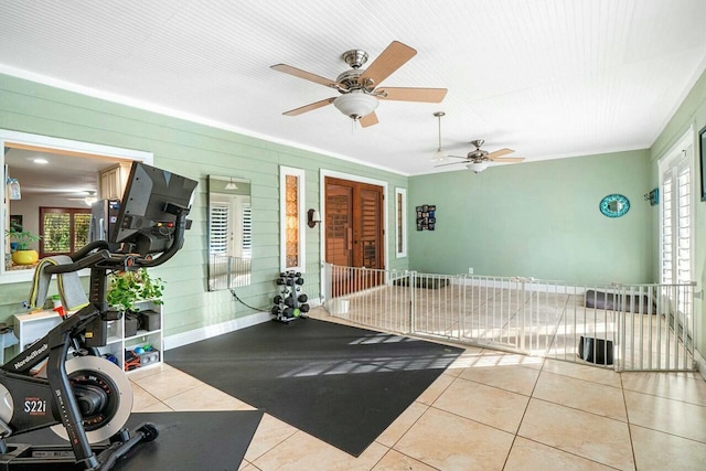 exercise room featuring baseboards and light tile patterned floors