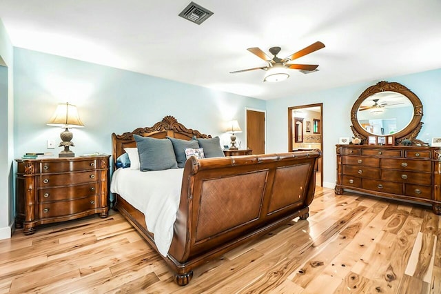 bedroom featuring ceiling fan, light wood-type flooring, visible vents, and baseboards