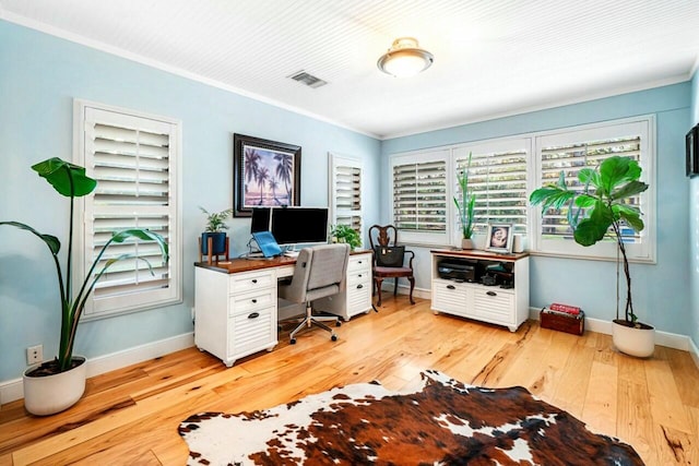 home office featuring baseboards, light wood-style flooring, visible vents, and a healthy amount of sunlight