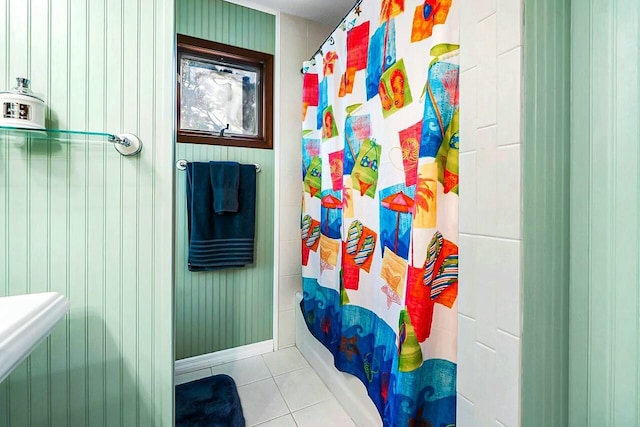 full bathroom featuring shower / bathtub combination with curtain, baseboards, and tile patterned floors