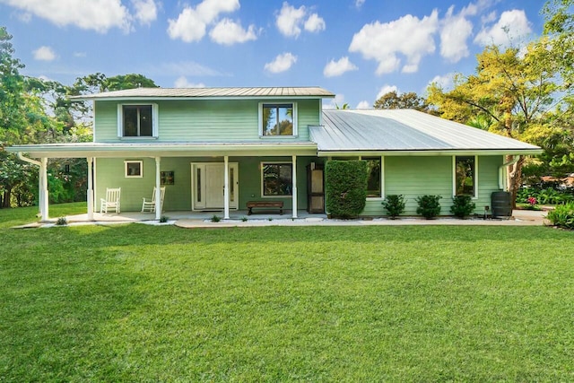 view of front of house featuring covered porch, metal roof, and a front yard