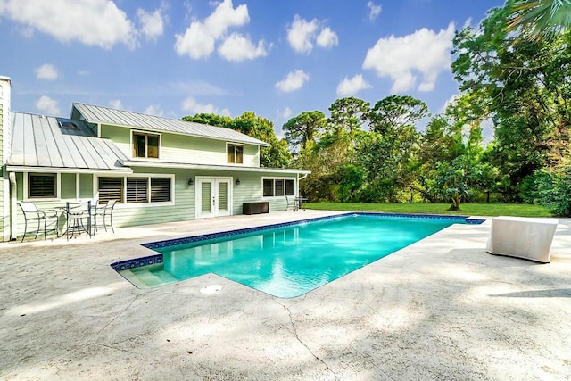 pool with french doors and a patio