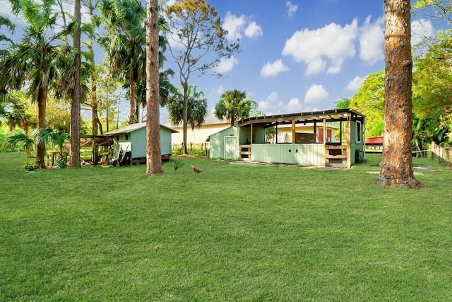 rear view of property featuring a lawn and an outbuilding