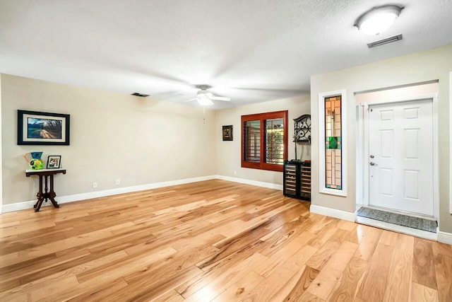 foyer featuring light wood-type flooring, visible vents, and baseboards