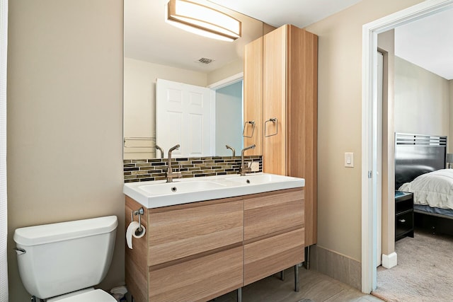 bathroom with tasteful backsplash, vanity, and toilet