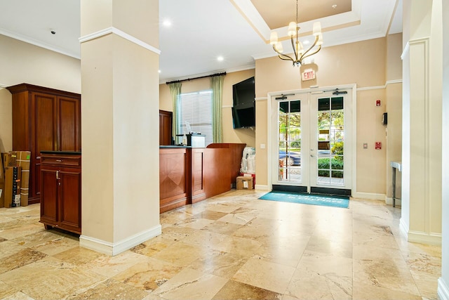 interior space with a chandelier, ornamental molding, a raised ceiling, and a high ceiling