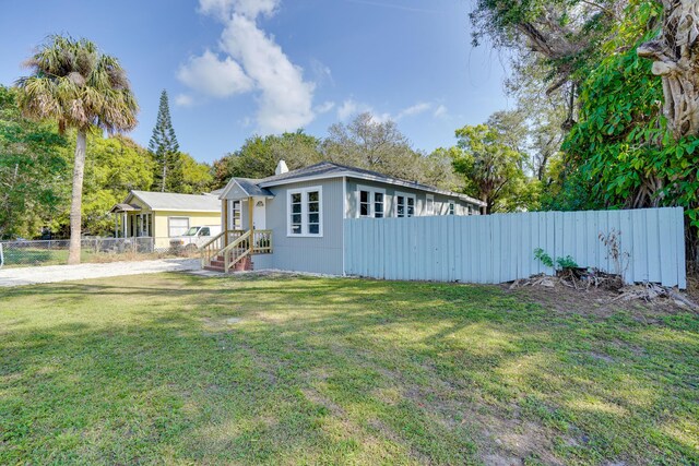 exterior space featuring a yard, a chimney, and fence private yard