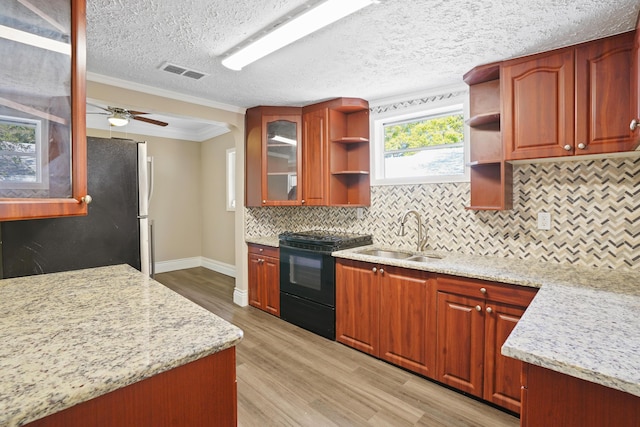 kitchen with open shelves, visible vents, electric range, glass insert cabinets, and a sink