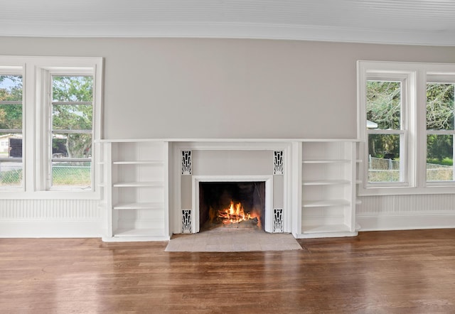 unfurnished living room with plenty of natural light, wood finished floors, and a fireplace with flush hearth