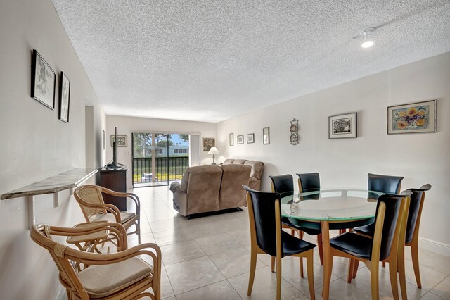 dining space with light tile patterned flooring and a textured ceiling