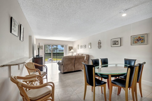 tiled dining space with a textured ceiling