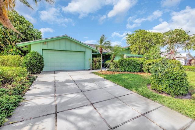 ranch-style home featuring a garage and a front lawn