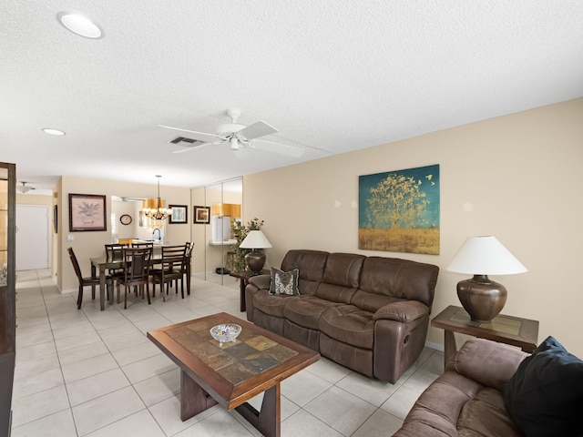 living room with light tile patterned floors, a textured ceiling, and ceiling fan