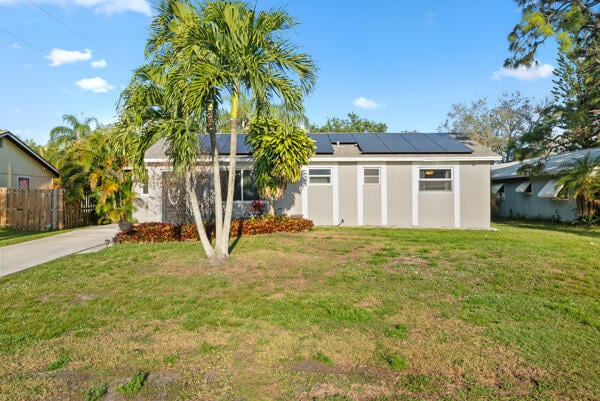 view of front of home featuring a front yard and solar panels