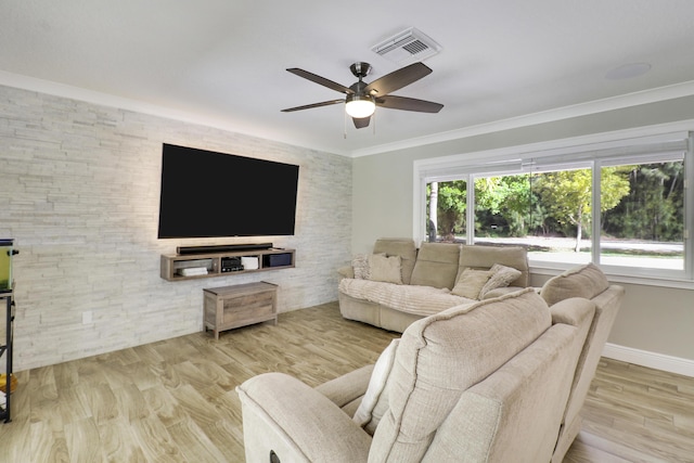 living room featuring ceiling fan, ornamental molding, a healthy amount of sunlight, and light wood-type flooring