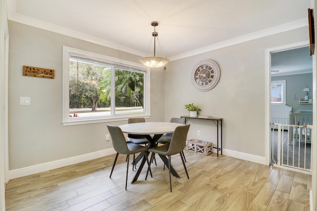 dining area with an inviting chandelier, crown molding, and light wood-type flooring