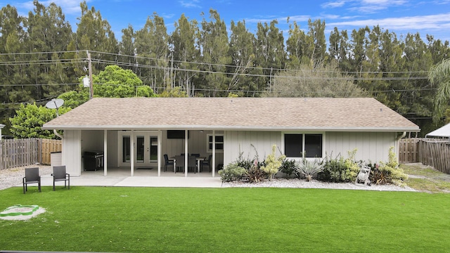 rear view of property with a lawn and a patio