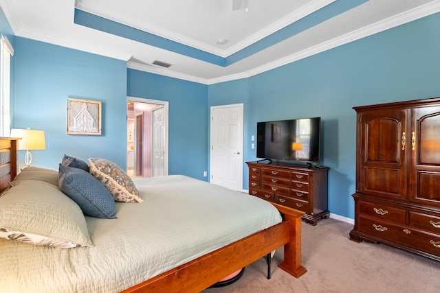 bedroom with ornamental molding, a tray ceiling, and light carpet