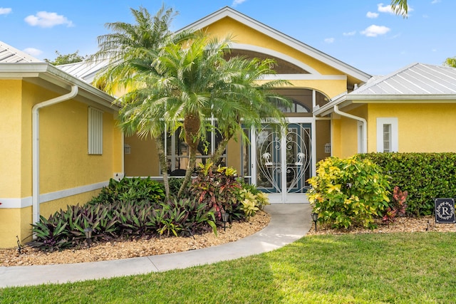 entrance to property featuring a lawn