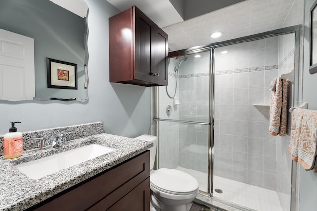 bathroom featuring walk in shower, vanity, and toilet