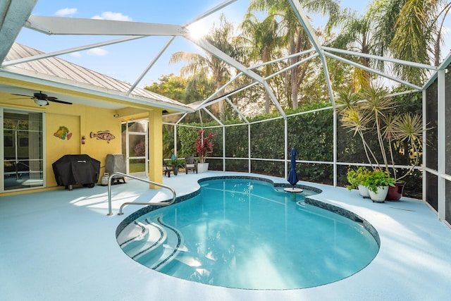 view of pool featuring ceiling fan, a grill, a patio area, and glass enclosure