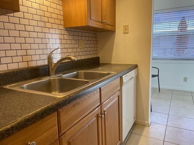 kitchen with dishwasher, sink, light tile patterned floors, and backsplash