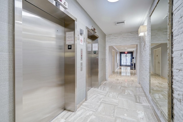 hallway with visible vents and elevator